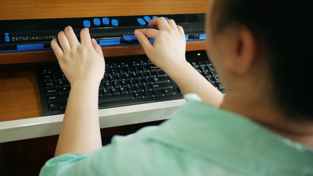 Accessibilità dei siti: una persona che usa un dispositivo di scrittura e lettura assistita